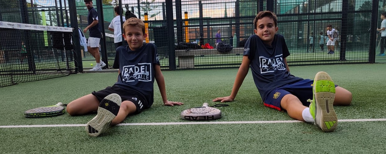 Dos alumnos de la escuela de Pádel La Salle realizando estiramientos en la pista